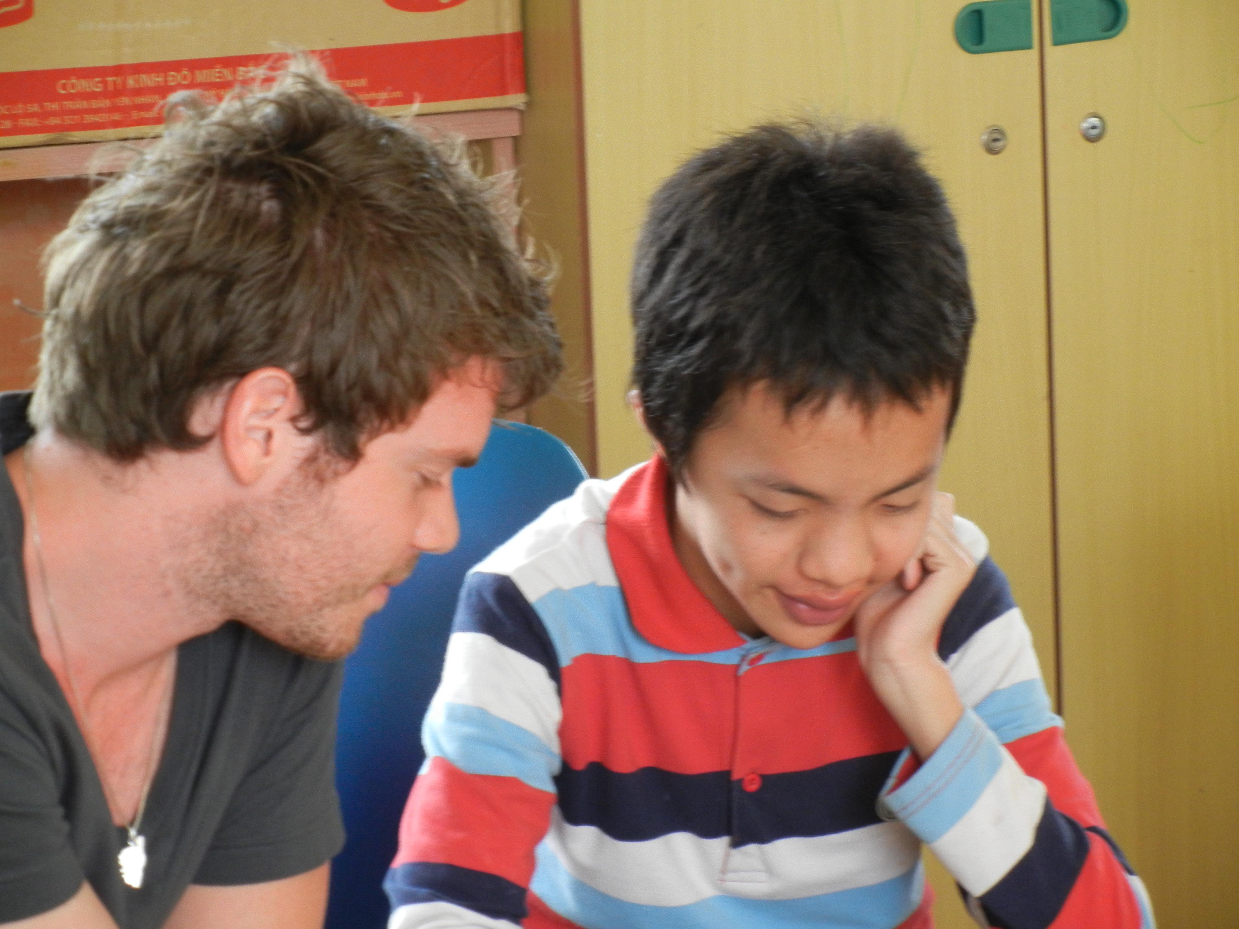 A young intern from projects Abroad teaching a child how to read as part of his speech therapy internship in Vietnam. Pictured is a young intern from Projects Abroad teaching a child how to read as part of his speech therapy internship in Vietnam.